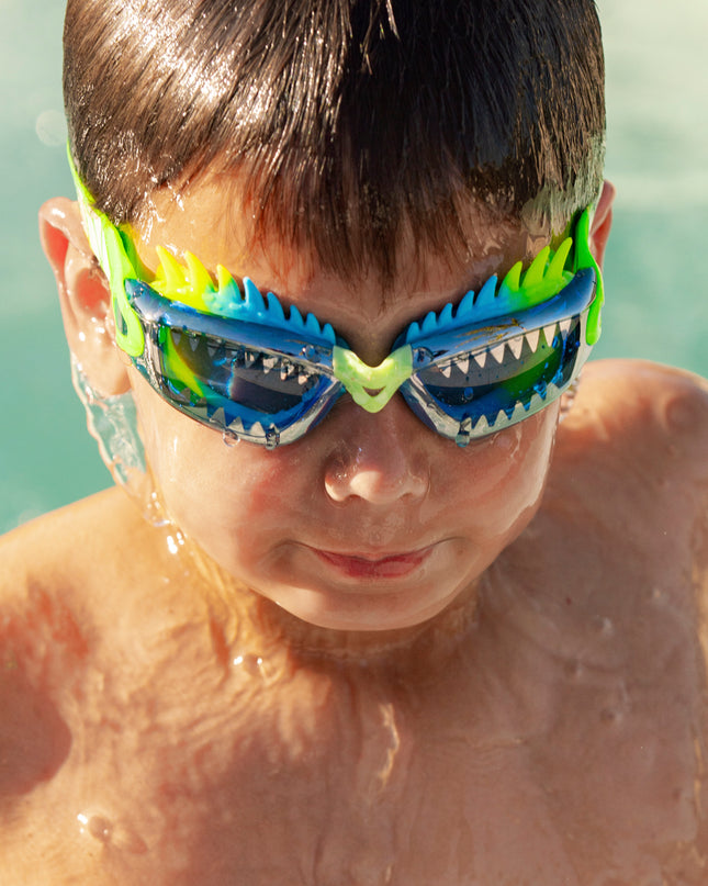 boy swimming getting out of pool wearing draco the dragon kids' swim goggles in sea dragon green showing silicone spiked gasket and sharp teeth printed lens
