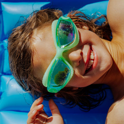 explore the pool kids swim goggles in sea green lifestyle of boy wearing sea green swim goggles on pool float