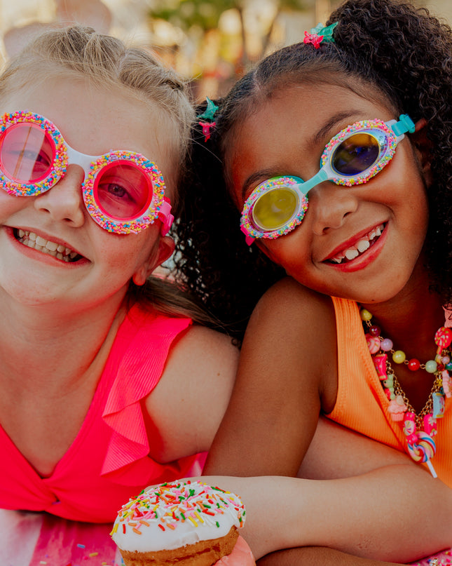 girls laying on beach towel with snacks in donuts 4 u kids' swim goggles and cake pop kids' swim goggles