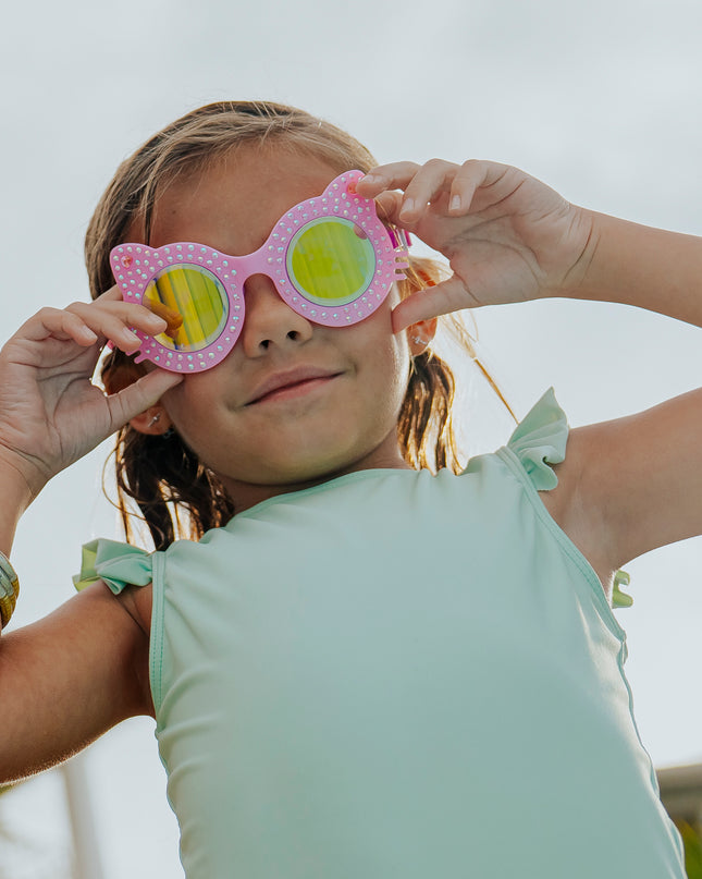 girl smiling looking at camera wearing kitten kids cat-shaped swim goggles in paw print pink showing rhinestone details