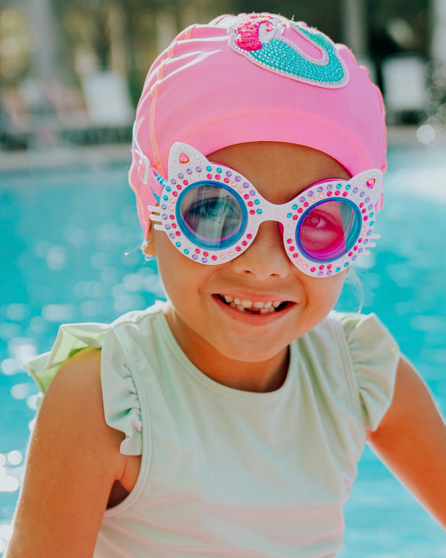 girl smiling in pool wearing kittens kids cat-shaped swim goggles in porcelain paws white showing multi colored rhinestones