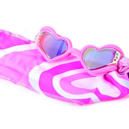Close-up glam shot of Soft Crush Pink Wish goggles styled on heart soft strap, highlighting iridescent lenses, rhinestones, and easy-on soft strap
