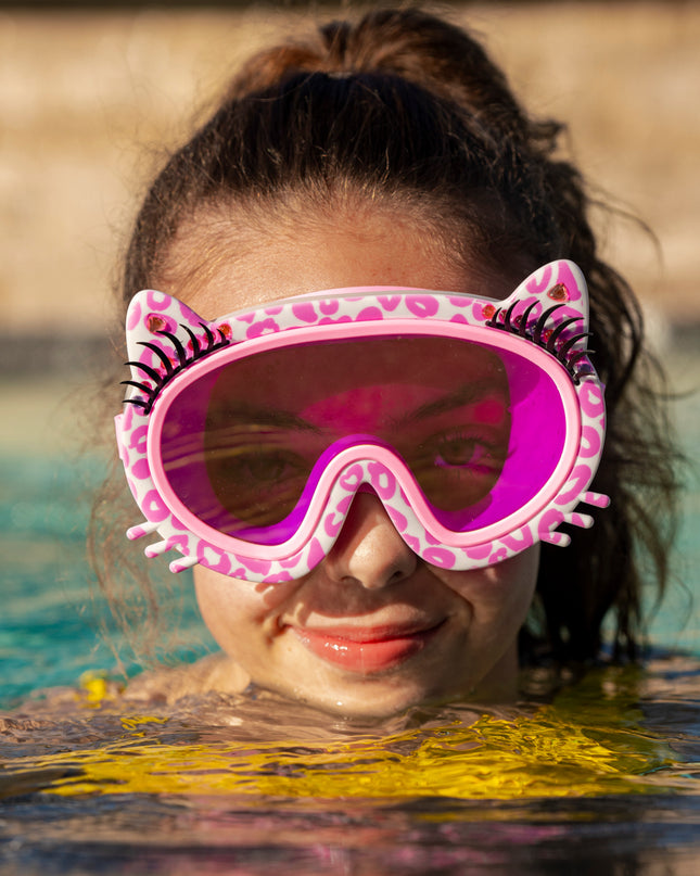girl swimming wearing meow kids' swim mask in copy cat pink showing pink cheetah printed frame, faux whiskers and eyelashes with rhinestone