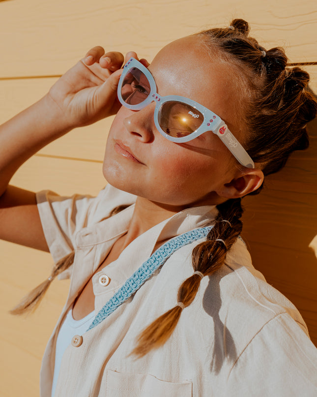 young girl posing wearing malibu beach kids' sunglasses in bay blue showing baby blue frame and detail