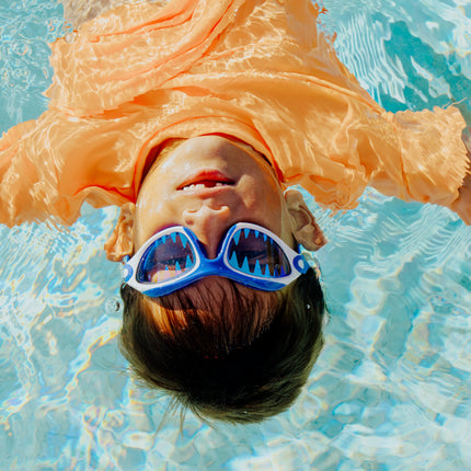 lifestyle image of child floating in pool wearing covert chomp in frost fin showing screen printed lens
