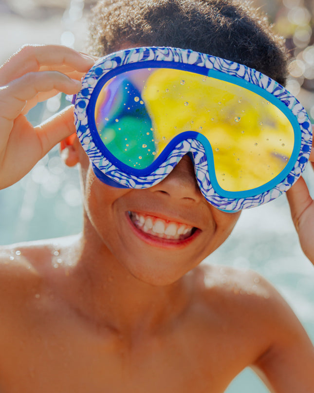 lifestyle image of boy smiling wearing dino dash swim mask showing reflective lens 