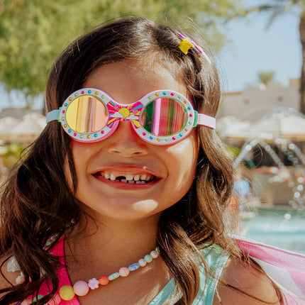 girl smiling standing in front of pool and sprinkler wearing sunrise sparkle showing round frame with sunrise detail and rhinestones