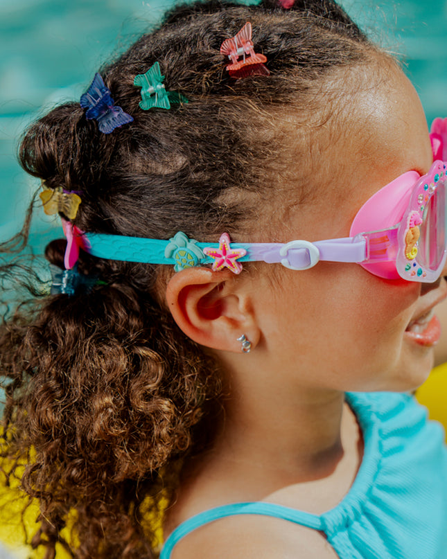 angled lifestyle image of girl in pool in enchanted shoreline showing turtle and starfish silicone strap sliders