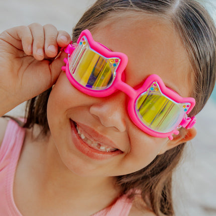 girl smiling wearing flexi feline kids swim goggles in jelly beans pink hot pink all silicone frame