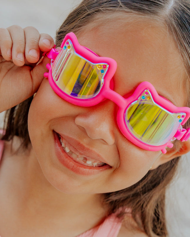 girl smiling wearing flexi feline kids swim goggles in jelly beans pink hot pink all silicone frame