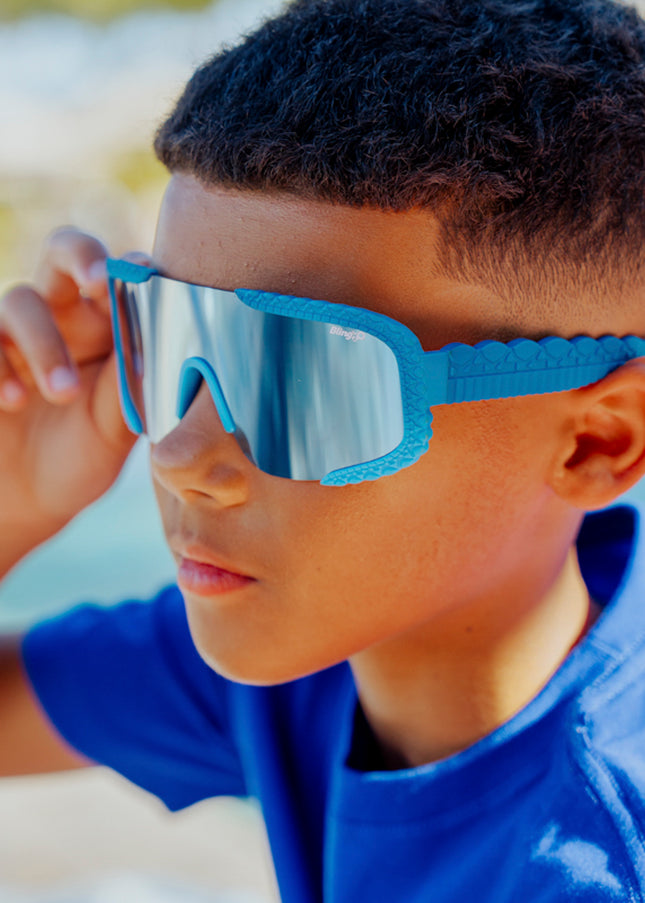 lifestyle of kid wearing gulfshore kids sunglasses in crocodile cobalt blue showing texture on frame and arm