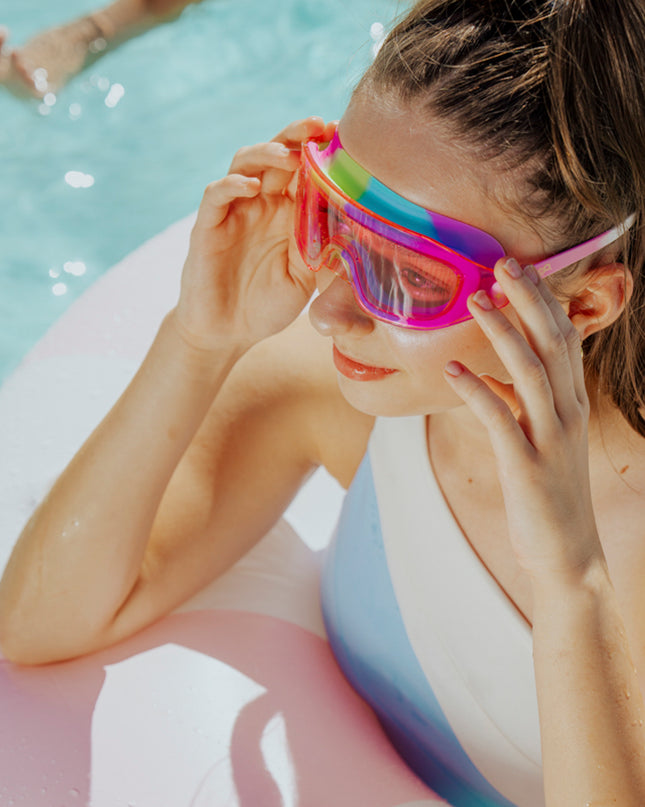 lifestyle of girl wearing hologlow swim goggles in pixel pink showing hot pink frame and swirl colored gasket