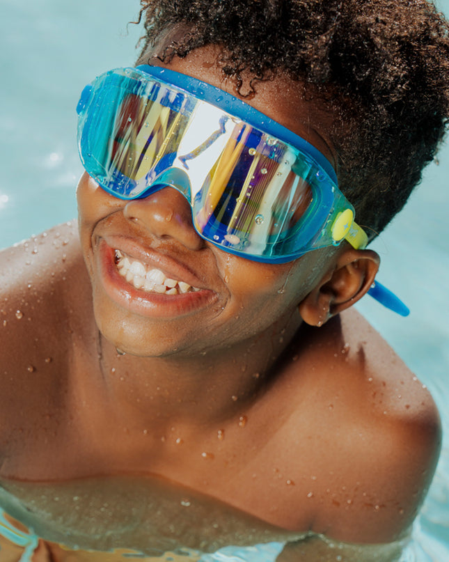 lifestyle of boy swimming wearing hologram kids swim goggles in polar stream showing frameless lens and blue gasket