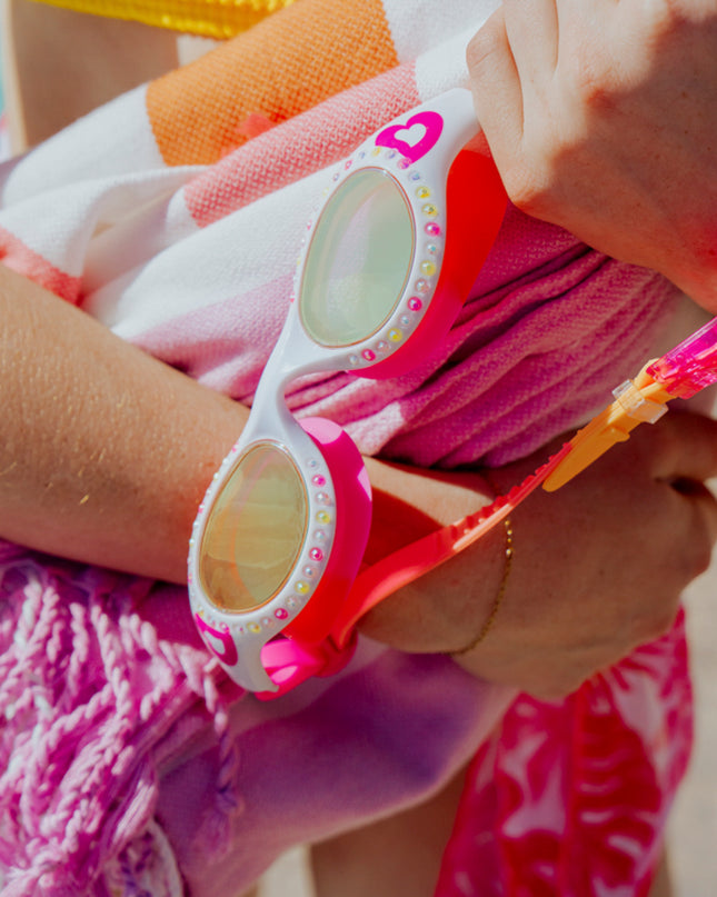 lifestyle showing love sparkles swim goggles in mang muse showing rhinestones and heart printed detail 