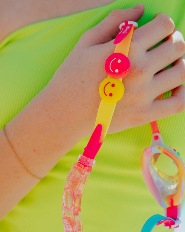 smile kids swim goggles being held showing two smiley faced silicone sliders