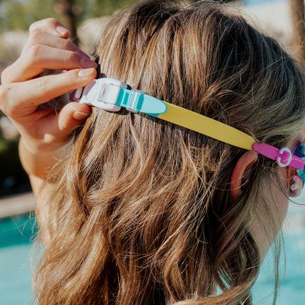 back view of girl wearing tie-dye tabby all silicone cat shaped swim goggles showing back clip