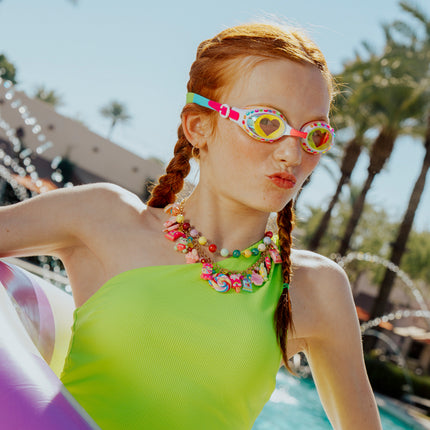 girl wearing smile kids swim goggles in positively pink showing rhinestones and heart printed lens