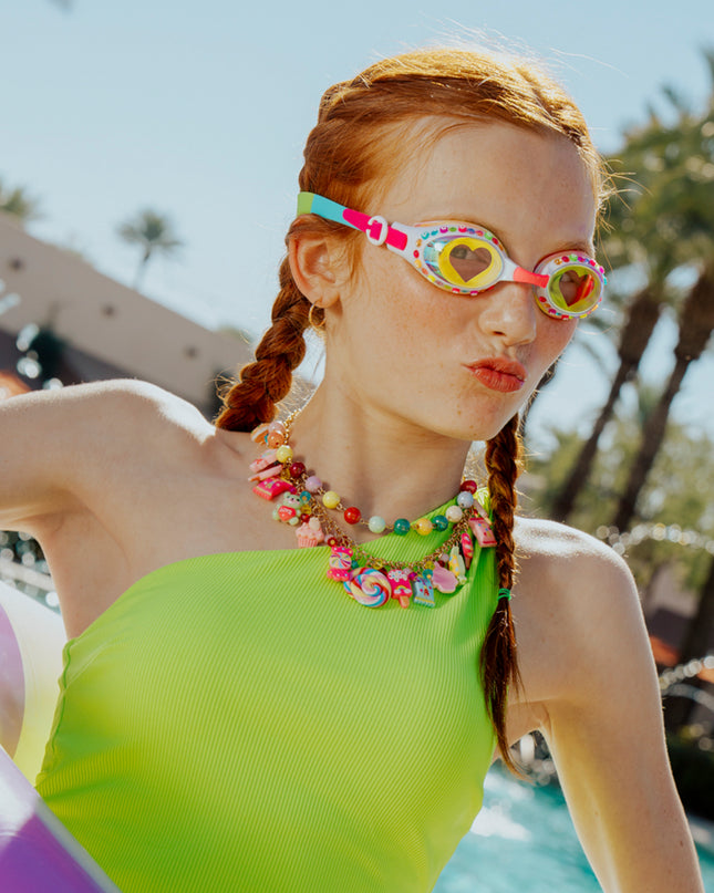 girl wearing smile kids swim goggles in positively pink showing rhinestones and heart printed lens