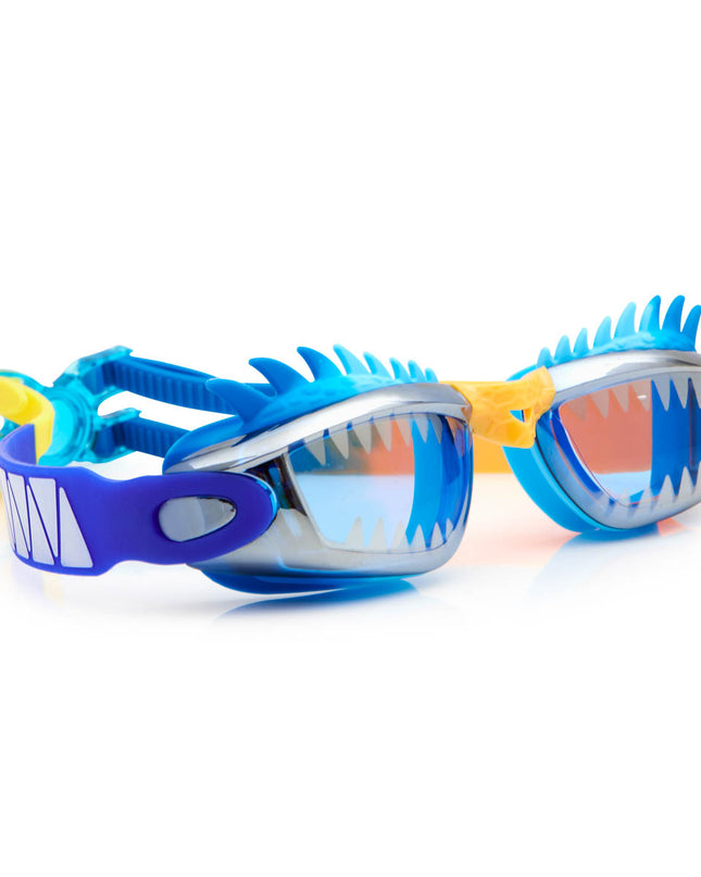 angled view of draco the dragon kids' swim goggles in blue dragon showing a silicone spiked gasket, sharp teeth printed lens and patterned strap